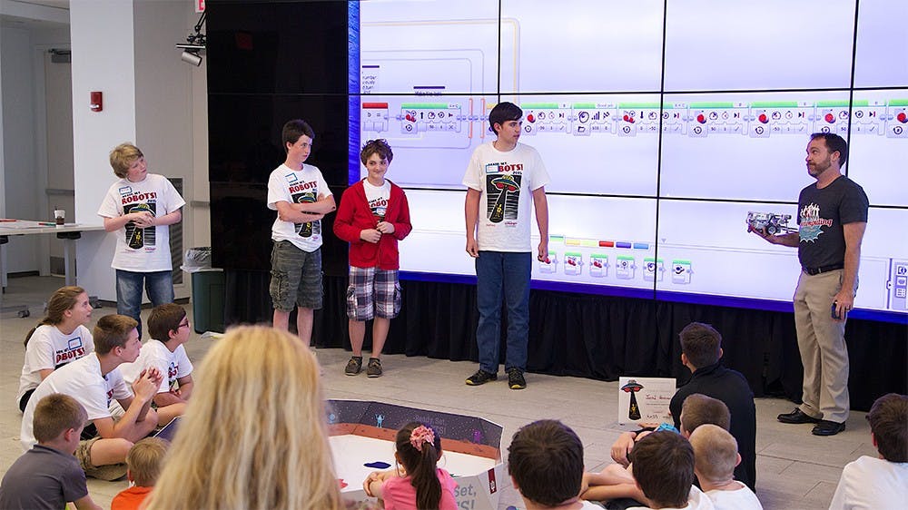 Robert Ping, right, the Manager of Education and Outreach at UITS, lectures students during the "Ready. Set, Robots!" workshop.  According to the camp's website, the workshop introduces teens to technology-related fields including programming, high performance computing, and neworking, while they work with IU technology professionals.