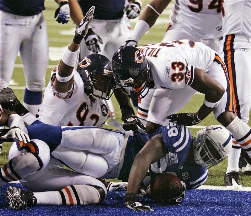 Indianapolis Colts running back Joseph Addai, bottom, is tackled by Chicago Bears defensive end Adewale Ogunleye, left, and cornerback Charles Tillman for a safety in the second quarter of an NFL football game on Sept. 7 in Indianapolis. Addai hasn't topped 50 yards in a game yet, the Colts are averaging 2.3 yards a carry and Peyton Manning already has been sacked four times. This isn't how Indianapolis is used to playing.