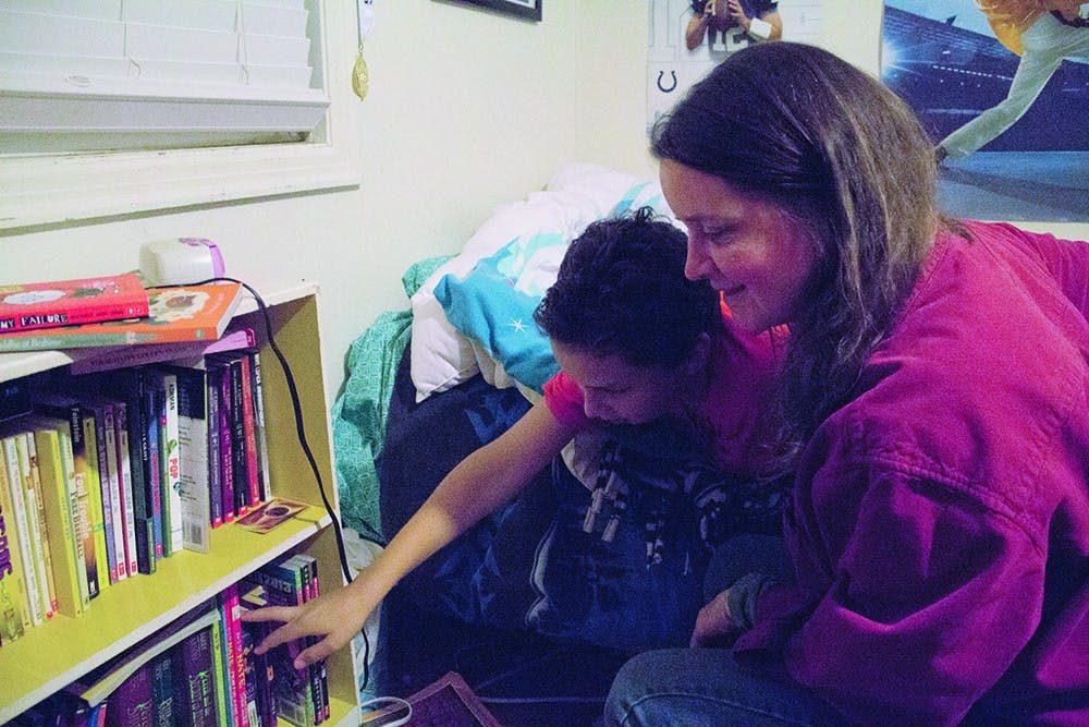 Cathy Fuentes-Rohwer picks out a book to read with her son, Mateo, before bed. Fuentes-Rohwer said it upsets her when time she spends advocating for public education cuts into time she could be spending with Mateo.  