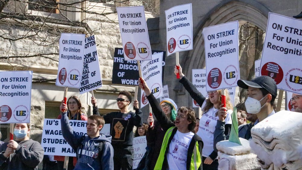 When a car honked in support, demonstraters cheered and hoisted their signs in the air April 14, 2022, outside Sample Gates. Mutiple picket lines are taking place outside IU buildings starting this week as the graduate workers look to be recognized as a union and fight for higher wages.