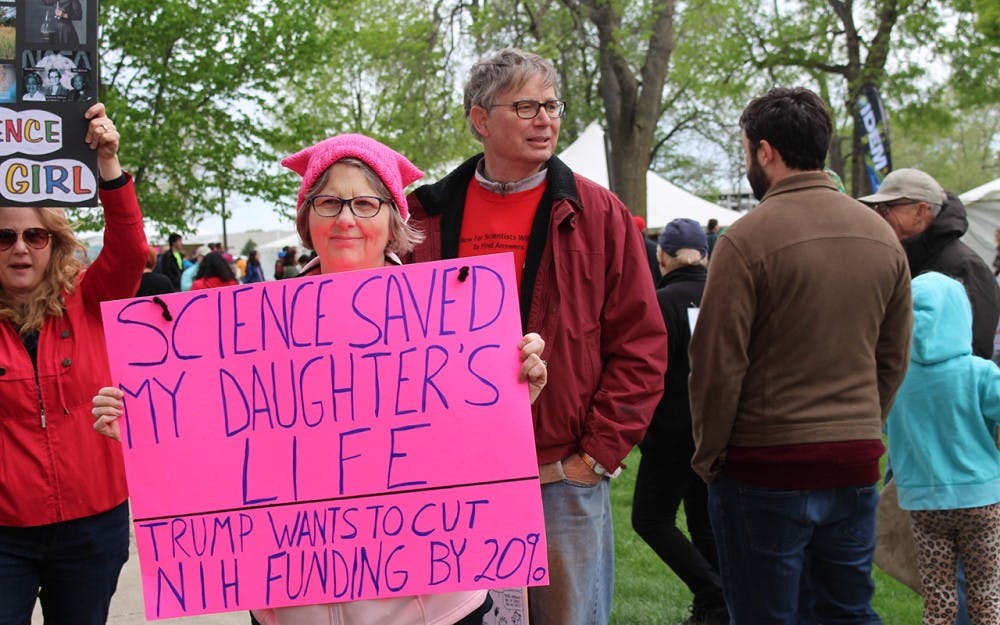 Patricia Gibson, 60, holds up a pink sign at the March for Science in Indianapolis. Gibson has a daughter who was diagnosed with Hodgkin’s disease and survived. Now she’s a PhD student, Gibson said. 
