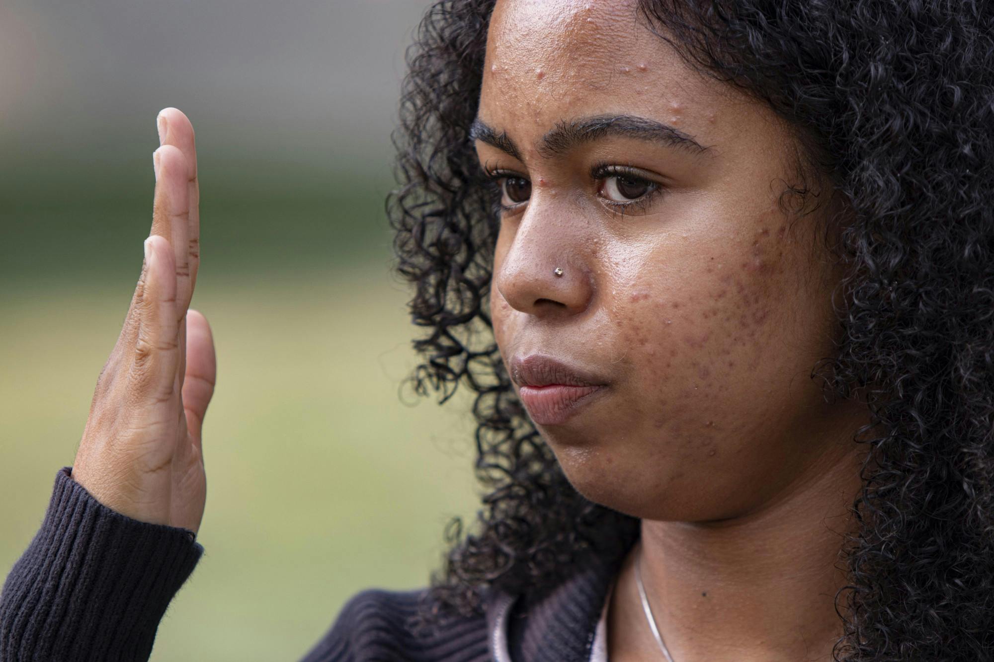 Junior Alice Aluko describes the act of bias she experienced her freshman year at IU on Sept. 15 at the corner of Third Street and Indiana Avenue. Aluko shows how close the verbal attacker was to her face with her hand.