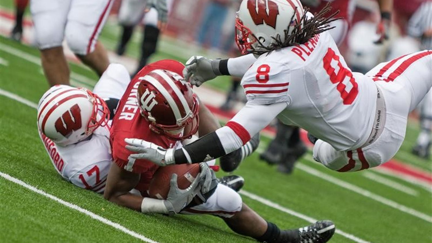 IU receiver Terrance Turner is tackled by Wisconsin's Mike Preisler (17) and Aubrey Pleasant (8) during IU's 55-20 loss on Saturday at Memorial Stadium.