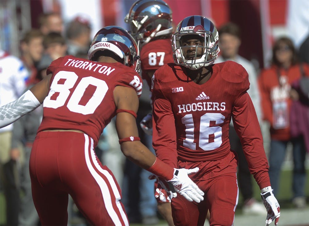 Cornerback Rashard Fant (16) high fives Leon Thornton III (80) before the game against Rutgers Saturday at Memorial Stadium. The Hoosiers lost, 52-55.