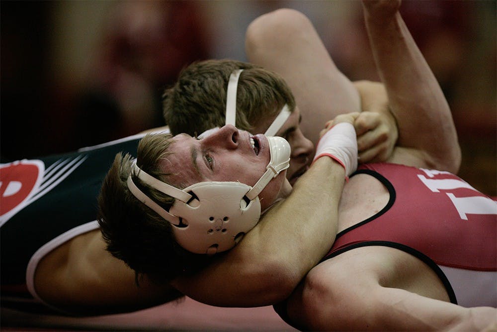  Freshman Bryce Martin struggles to escape SIU opponent Nate Higgins, seconds before Higgins pinned Martin. 