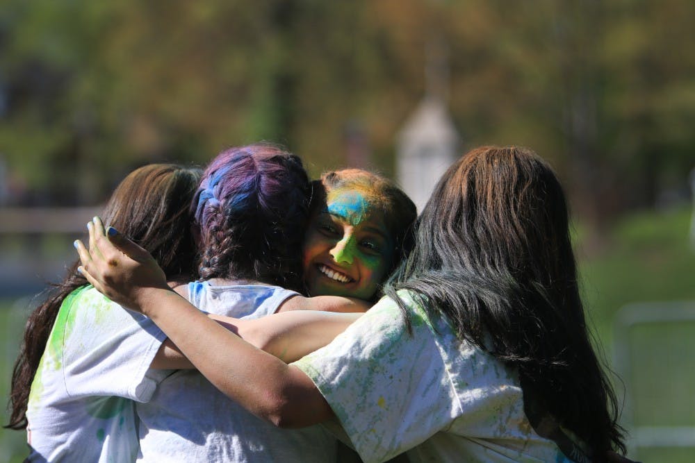 4月21日，在庆祝胡里节的Dunn Meadow表演后，Jhanak成员在印第安纳大学拥抱。参加活动的人向空中和彼此投掷彩色粉末。