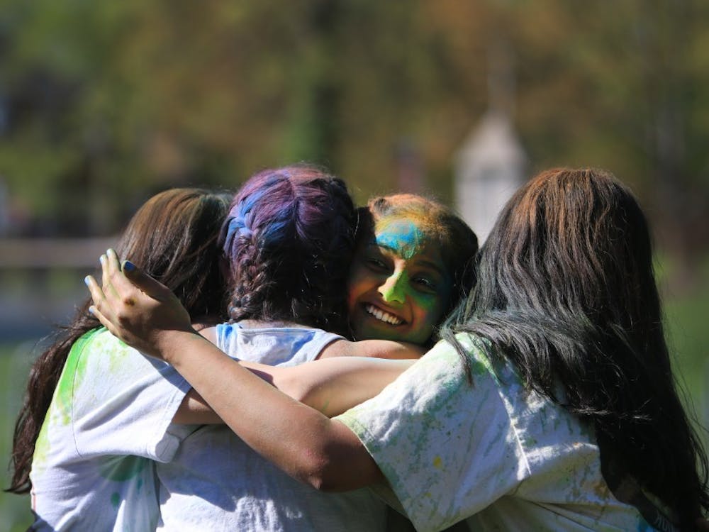 Members of Jhanak at IU hug after performing April 21 in Dunn Meadow during the celebration of Holi. Participants at the event threw colored powder in the air and on each other.