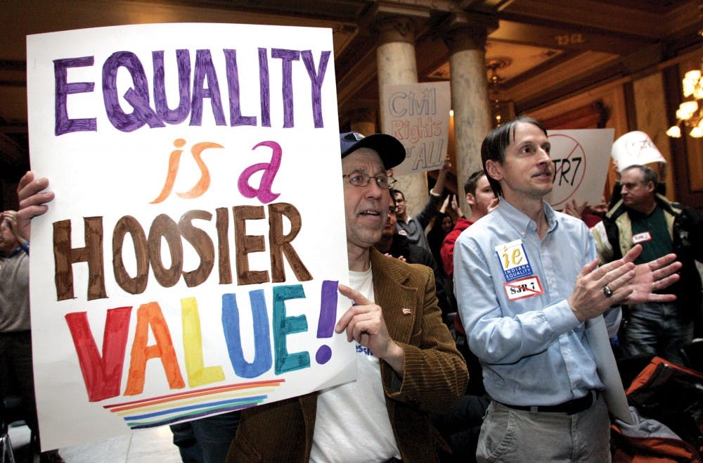 Jon Twurog, left, of Noblesville, Ind., and Steve Adams, right, of Indianapolis, applaud while attending an “Equality is a Hoosier Value!” rally at the Statehouse Monday in Indianapolis. Indiana Equality staged the rally to denounce Senate Joint Resolution 7, which would ban same-sex marriages. 