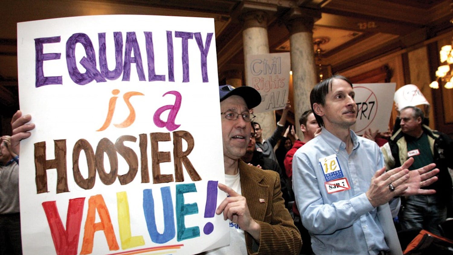 Jon Twurog, left, of Noblesville, Ind., and Steve Adams, right, of Indianapolis, applaud while attending an “Equality is a Hoosier Value!” rally at the Statehouse Monday in Indianapolis. Indiana Equality staged the rally to denounce Senate Joint Resolution 7, which would ban same-sex marriages.