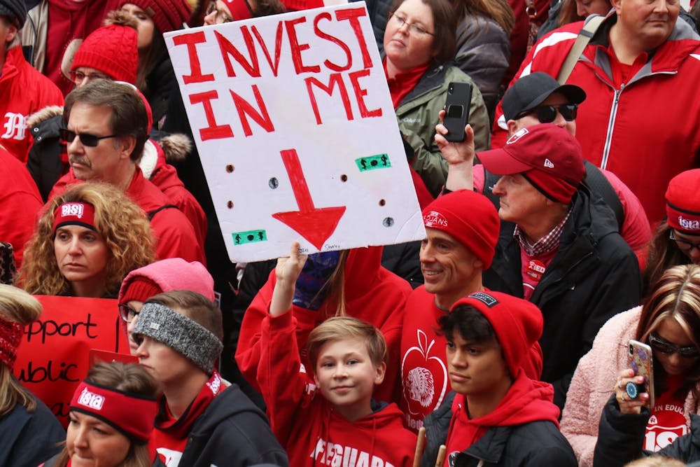 <p>An Indiana student holds a sign that reads &quot;invest in me&quot; Nov. 19 at the Indiana Statehouse in Indianapolis.</p>