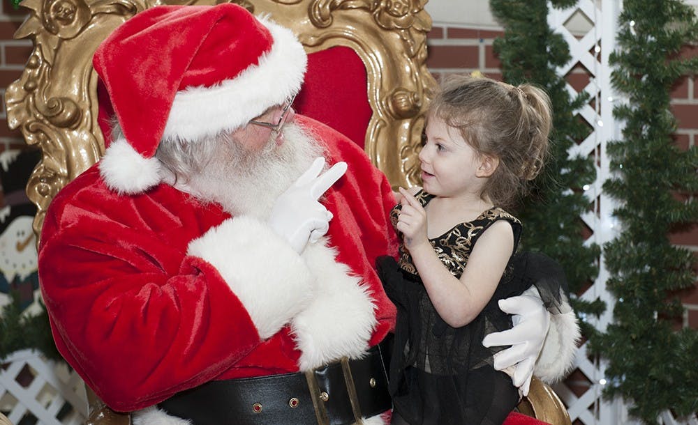 Three-year-old Chloe Patton tells Santa her Christmas wishlist Saturday at Fountain Square Mall. Many of the kids that attended Holiday Hoopla, an annual event hosted by Girls Inc., got to speak with Santa.