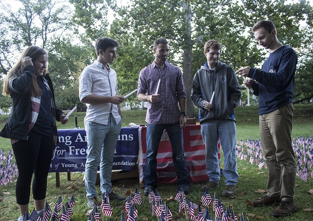 Members of the IU chapter of Young Americans for Freedom light their candles in a memorial for victims of the attacks on September 11, 2001, on Saturday in Dunn Meadow.