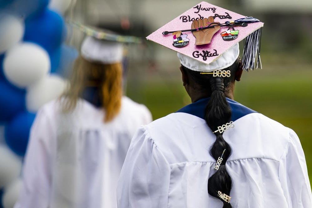 Anti Kenchele戴着一顶毕业帽，上面写着“年轻的黑人和天才”。2020年8月5日，在密歇根州卡拉马祖。