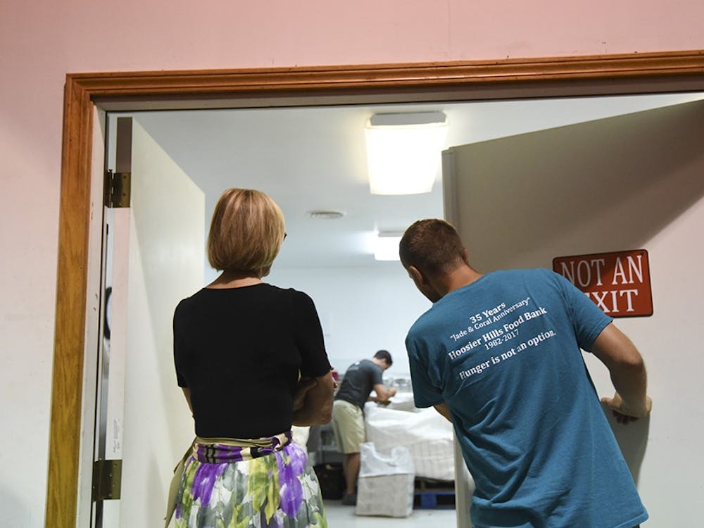 IU intern Ryan Mccauley leads Suzanne Crouch into a cold room where volunteers bag potatoes. The Hoosier Hills Food Bank has 2,000 volunteers per year.