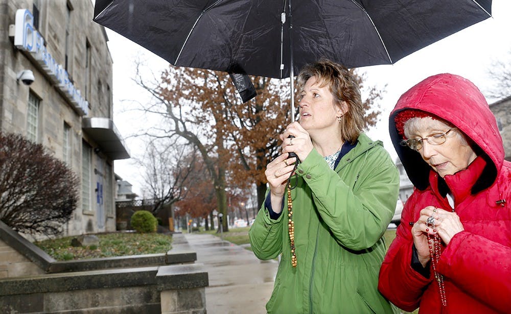 Brenda Preusz, left, and Barbara Dugan from Saint Bartholomew Catholic Church in Columbus, Ind. pray Thursday in front of Planned Parenthood. Prayers and protestors gather in front of the building every Thursday when abortion is proceeded. 
