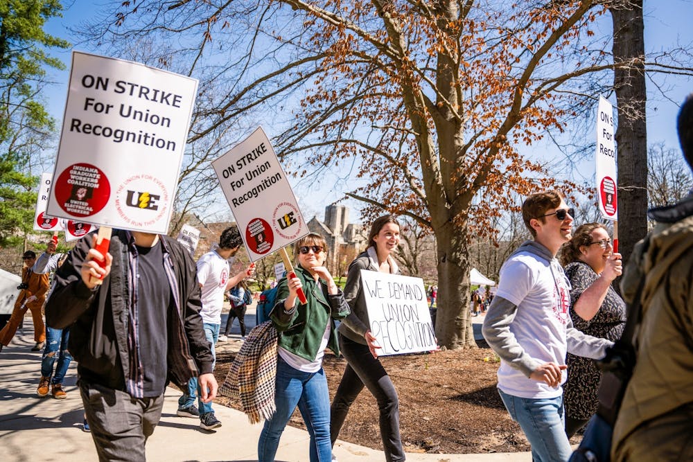 <p>Protestors march through campus April 14, 2022. The College of Arts and Sciences will reduce compensation and cut health care for its graduate workers starting in fall 2023.</p>
