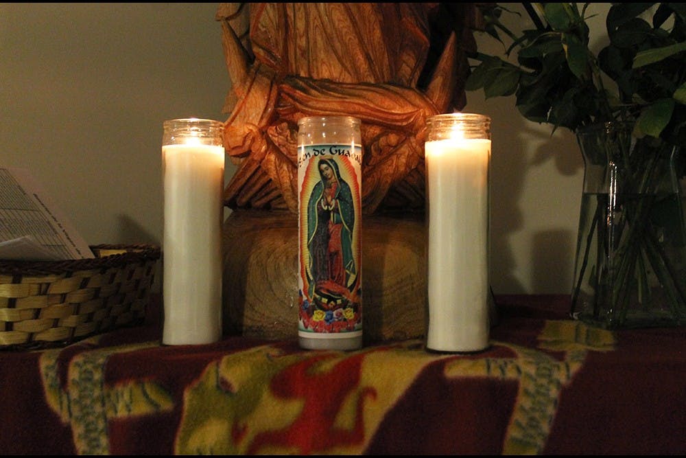 Roses, candles and the statue of the Virgin of Guadalupe is displayed during a rosary. In the origin story of the Virgin, she appeared to Juan Diego telling him to gather roses on the Hill of Tepeyec, a miracle since the hill should have been bare in December.