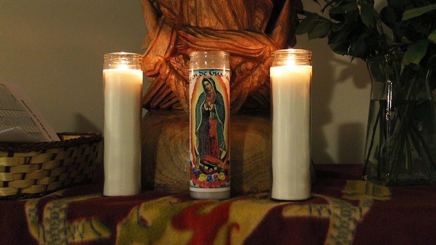 Roses, candles and the statue of the Virgin of Guadalupe is displayed during a rosary. In the origin story of the Virgin, she appeared to Juan Diego telling him to gather roses on the Hill of Tepeyec, a miracle since the hill should have been bare in December.