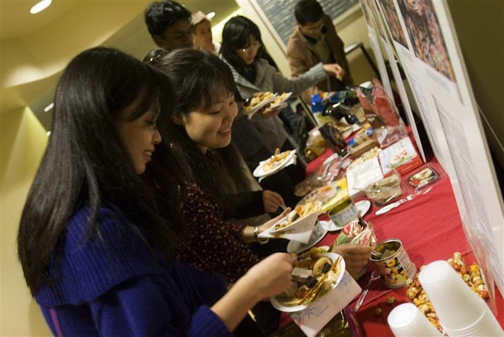 IU sophomore Jing Huang (left) and junior Minori Inada fill their plates with free food from around the world during the International Food Festvial Thursday night in the Leo R. Dowling International Center. The event was co-sponsored by Foster International and the Global Village.