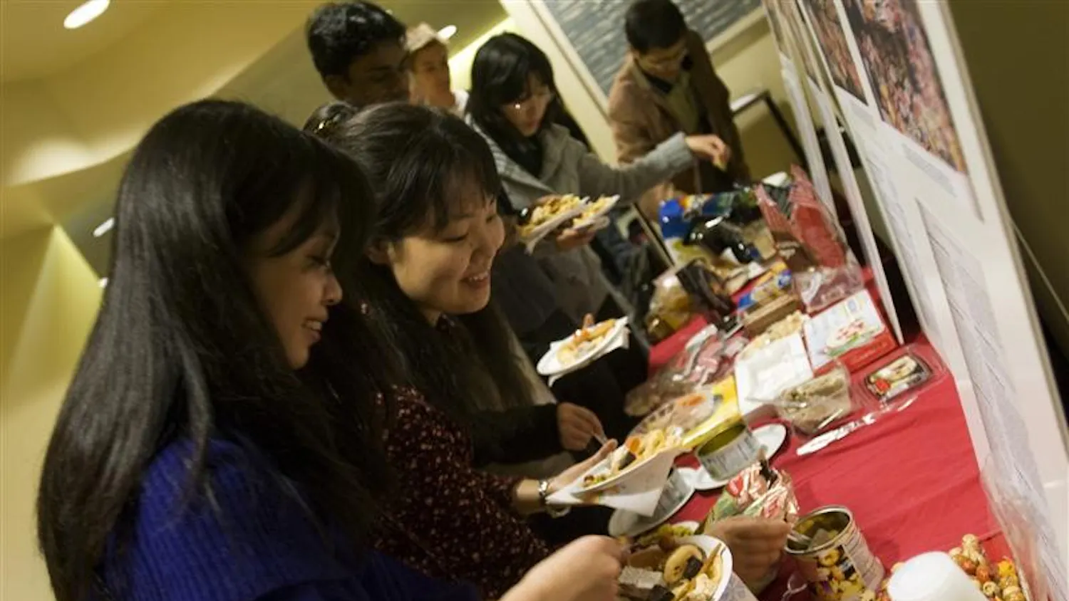 IU sophomore Jing Huang (left) and junior Minori Inada fill their plates with free food from around the world during the International Food Festvial Thursday night in the Leo R. Dowling International Center. The event was co-sponsored by Foster International and the Global Village.