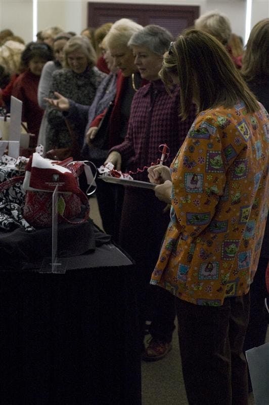 An attendee places a bid on a purse on Thursday morning at the Bloomington Convention Center. The Women & Heart Disease event focused on raising awareness for heart disease amongst women. It is the leading cause of death of women in the United States.