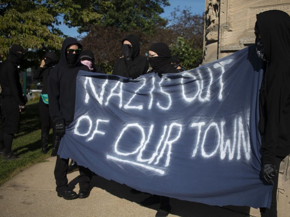 Members of antifa hold a large banner stating, “Nazis out of our town” Aug. 24 outside the Monroe County Courthouse in Bloomington. The group, along with members of No Space for Hate, marched to the Bloomington Community Farmers’ Market to protest Schooner Creek Farm, which is allegedly run by people who have ties to the white nationalist group  American Identity Movement.