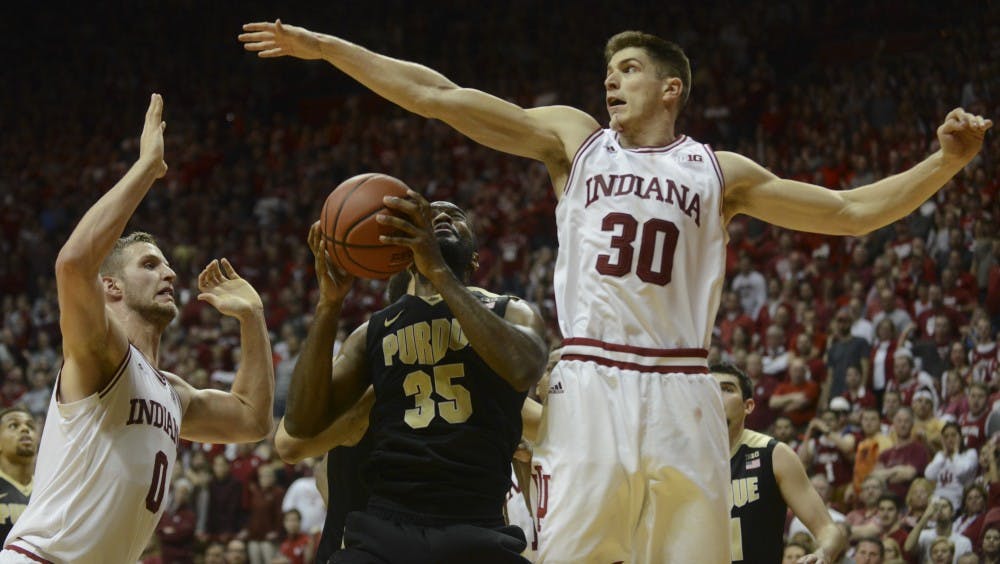 Redshirt senior forward Max Bielfeldt (9) and junior forward Collin Hartman (30) guard Purdue senior guard Raphael Davis on Saturday at Assembly Hall. The Hoosiers won 77-73.