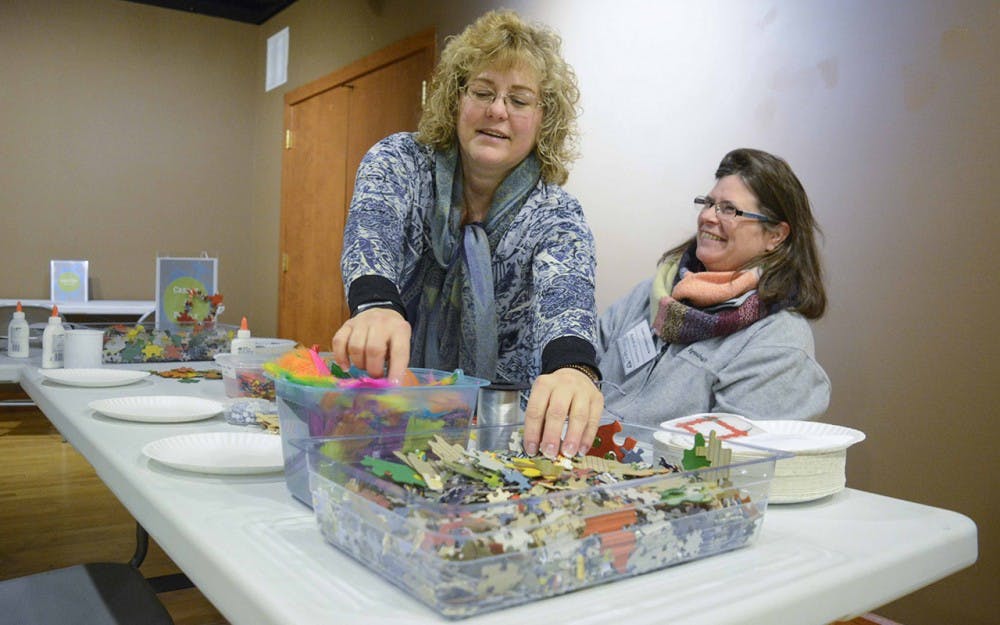 Lisel Loudermilk (right) , Board of Trustees, and Lisa Kroll (left), new member of Monroe County Historic Center, are assisting the visitors to solve puzzles at the Monroe County Historic Center on the National Puzzle Day.  