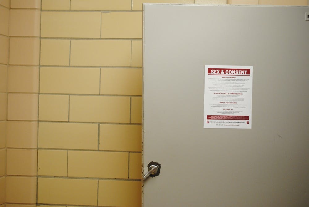 <p>IU plasters flyers, like this one in Ballantine Hall, in nearly every bathroom stall on campus, reminding students of what it means to ask for and give consent. Lawyers for those accused of sexual assault in the University's system say IU's definitions of consent are too simplistic.</p>