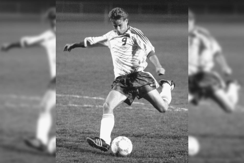Men's soccer player Ken Snow kicks the ball during his time on the team from 1987-1990. Snow won a national title with the team in 1988.