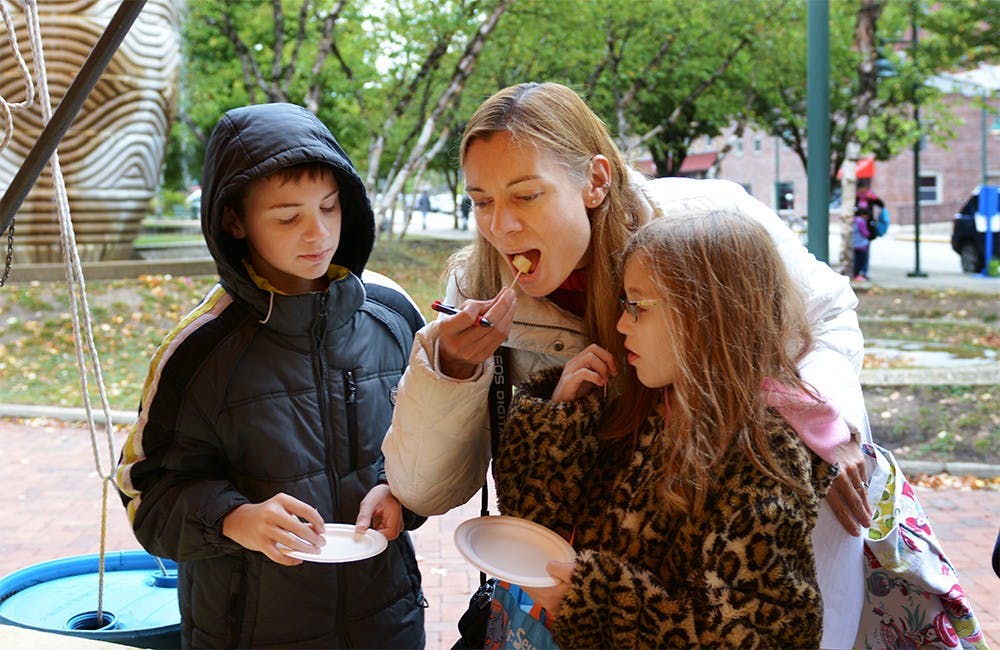 Lisa Wilson tastes sliced apples with her son Tyler and daughter, Dilana at the Farmers' Market on Saturday morning. The apple tasting event showcased 30 different kinds of apples with a total counts around 600 apples. "It's perfect fall event," said Wilson. 