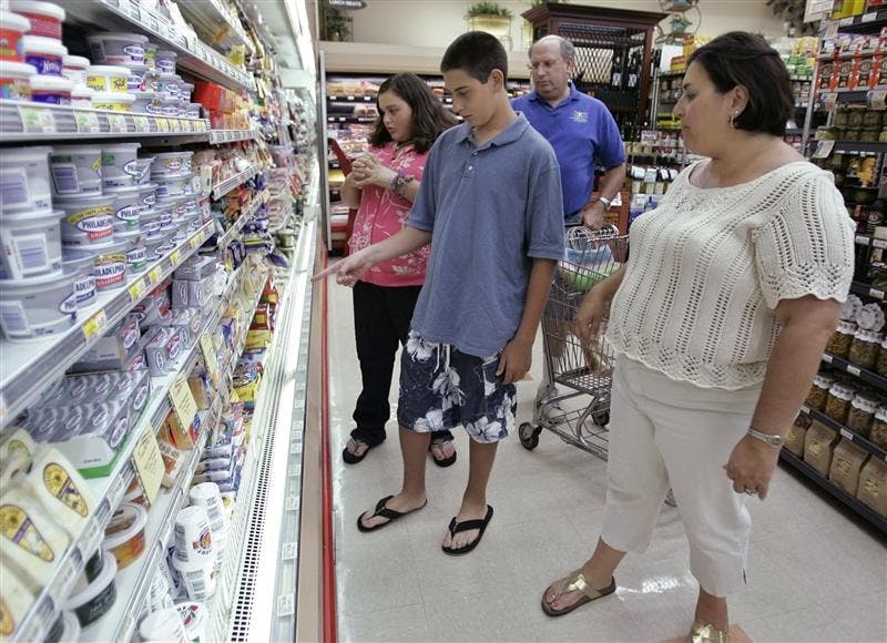 Jordana Bischoff, 12, left, her brother Nate, 14, center left, father, Howard, center right, and mother, Hollis, far right, shop for cheese Wednesday at Piazza's grocery store in Palo Alto, Calif.