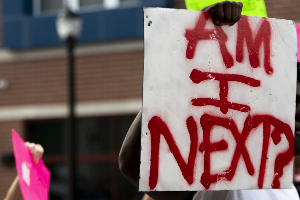 A protester holds a sign June 1 on East Third Street. The protest went through the streets as traffic was blocked off. 