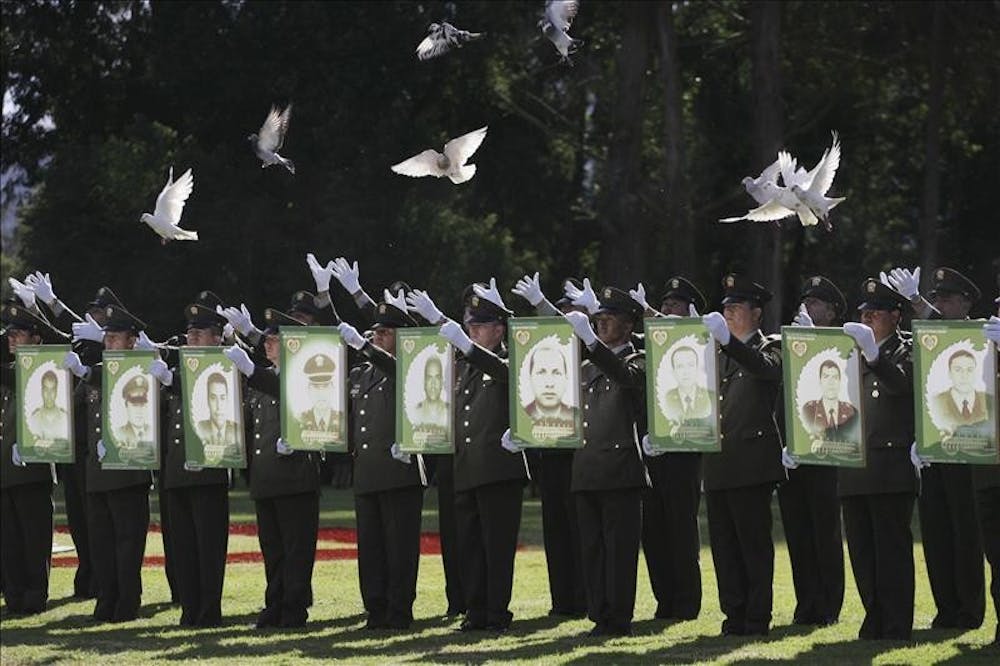 Police officers released pigeons while holding pictures of fellow officers kidnapped by rebels of the Revolutionary Armed Forces of Colombia, or FARC, Wednesday during a military ceremony in Sibate, Colombia.