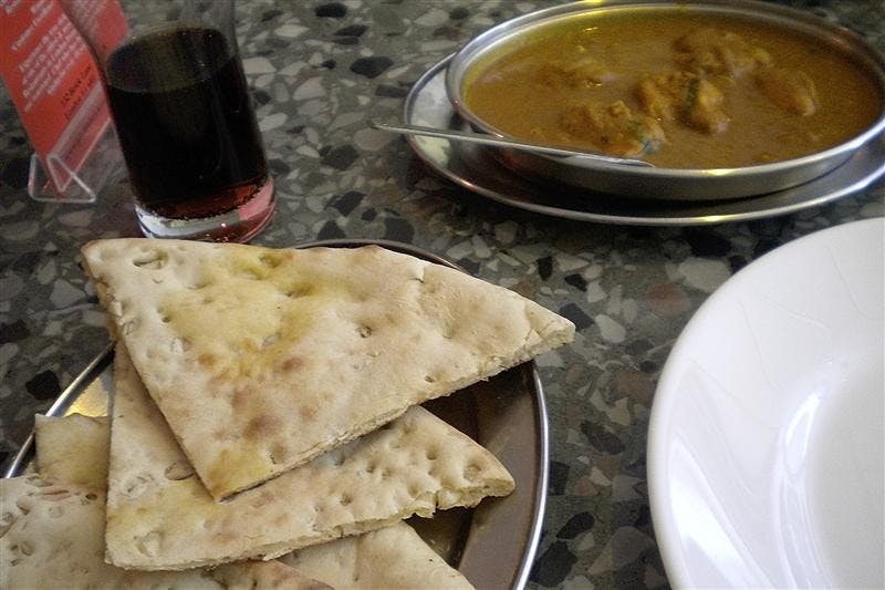 The restaurant Aladin in London serves a vegetable curry with garlic naan, a traditional Indian flatbread.