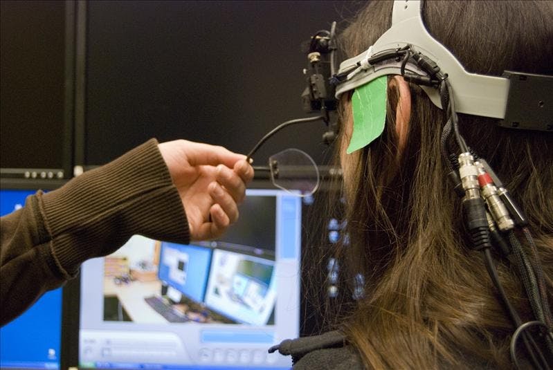 Lab assistant Amanda Favata lends a hand to assistant Thomas Smith as they calibrate an eye tracker headset at the Psychology building Monday afternoon. Favata and Smith were preparing for a psychology experiment run by Dr. Chen Yu, Assistant Professor of Psychological and Brain Sciences.
