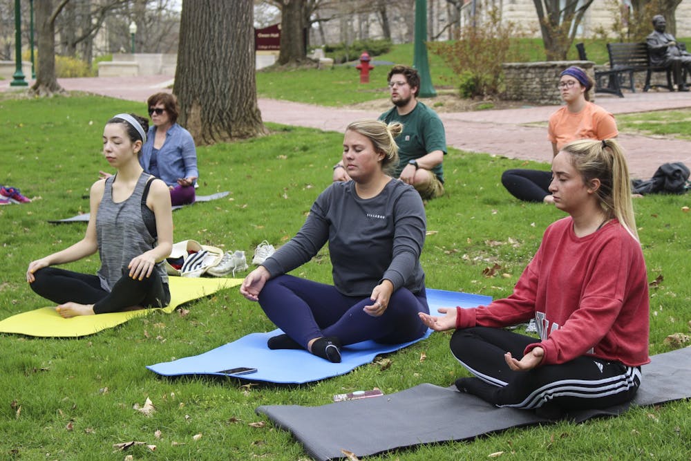 Participants of the Woodland Yoga Tour meditate April 22, 2018, in Dunn Woods. Yoga is one of many ways students can de-stress and calm themselves throughout the semester.