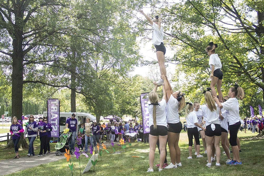 Cheerleaders from Midwest Cheer encourage walkers as they begin the Alzheimer's Association Walk to End Alzheimer's at Bryant Park on Sunday. Walkers were also given flower pinwheels to hold that represented whether they had, had lost someone or were taking care of someone with alzheimer's disease.