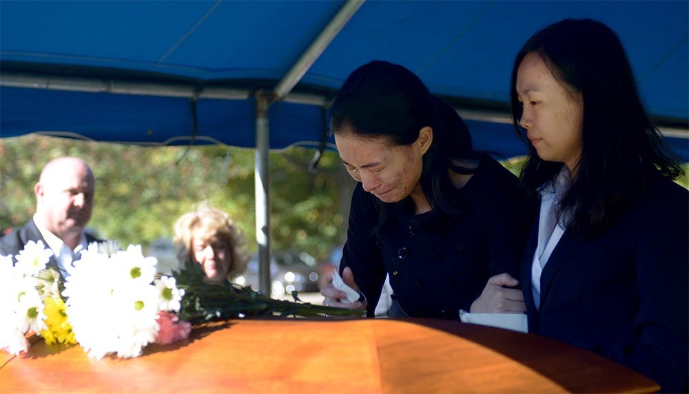 Yan Li, Yaolin Wang's cousin, holds Jielin Wang, Wang's sister, in front of Yaolin's casket before it went underground during the burial service on Oct.11.  Jielin was the last one to leave after the casket was in the ground.