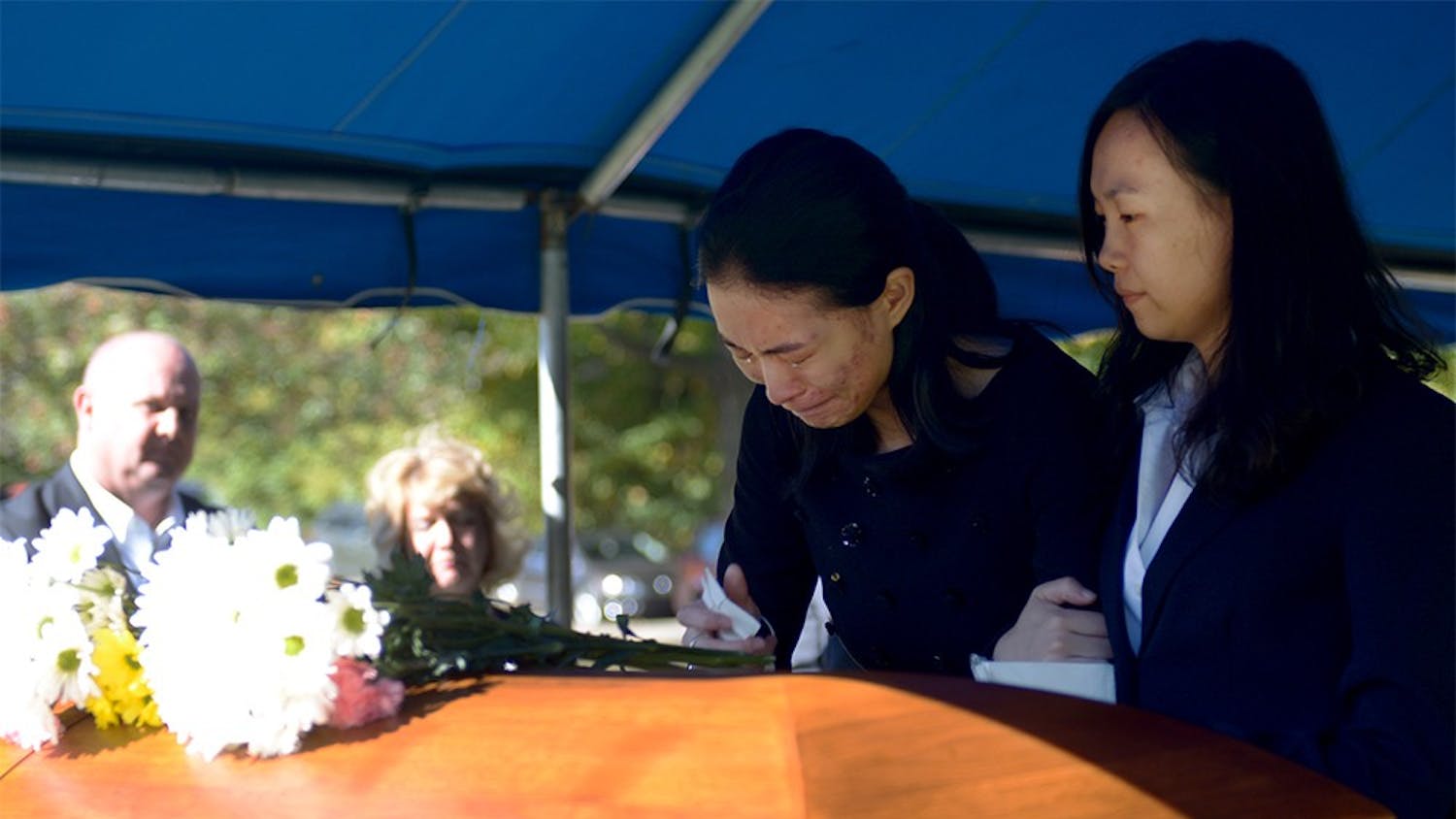 Yan Li, Yaolin Wang's cousin, holds Jielin Wang, Wang's sister, in front of Yaolin's casket before it went underground during the burial service on Oct.11.  Jielin was the last one to leave after the casket was in the ground.