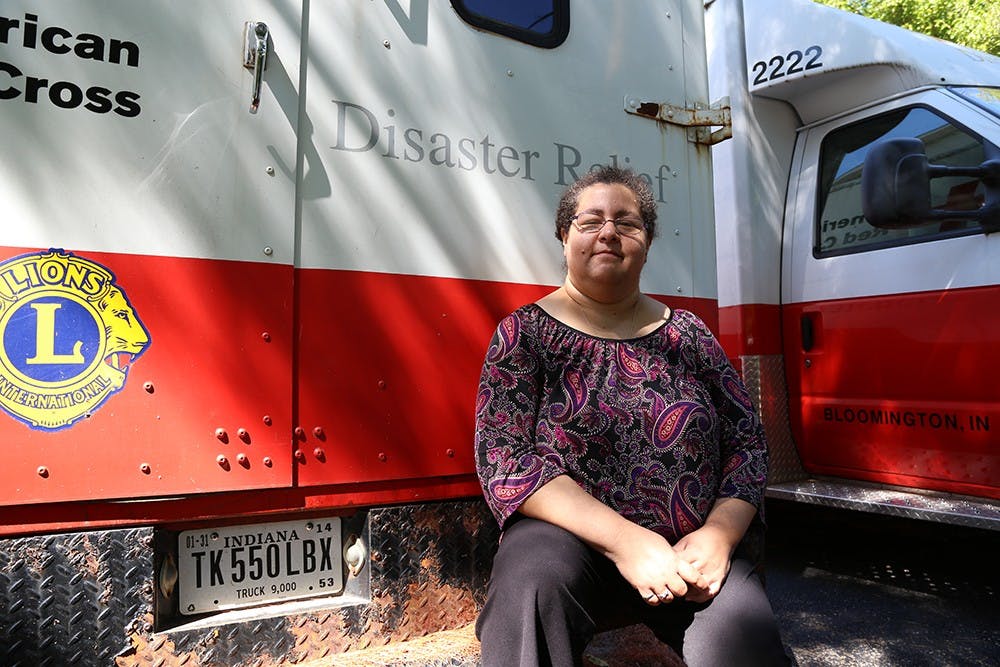 Maria Carrasquillo sits on the bumper of an emergency response vehicle that was used to assist responders at Ground Zero in New York in the days following Sept. 11.