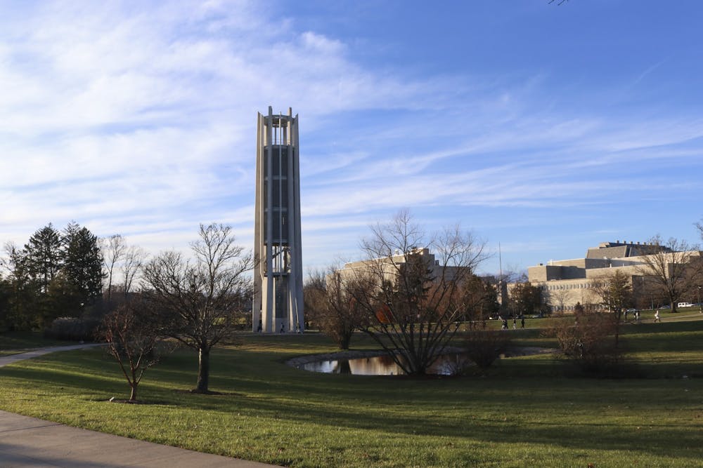 <p>Students walk to past the Arthur R. Metz Bicentennial Grand Carillon on Dec. 6, 2021, in the arboretum. Student environmental groups are calling for IU to make a commitment to climate action based on a resolution written by IUSG last year.</p>