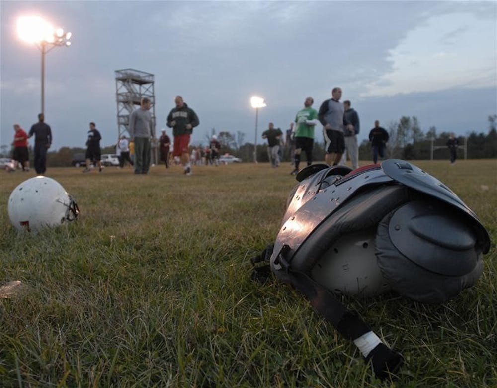 Members of the Cutters football team warm up at the beginning of practice Thursday night at Brown Elementary School in Bloomington.  The Cutters are a semi-professional football team with several former IU players competing in the Interstate Football League, a league with teams from Indiana and Ohio.