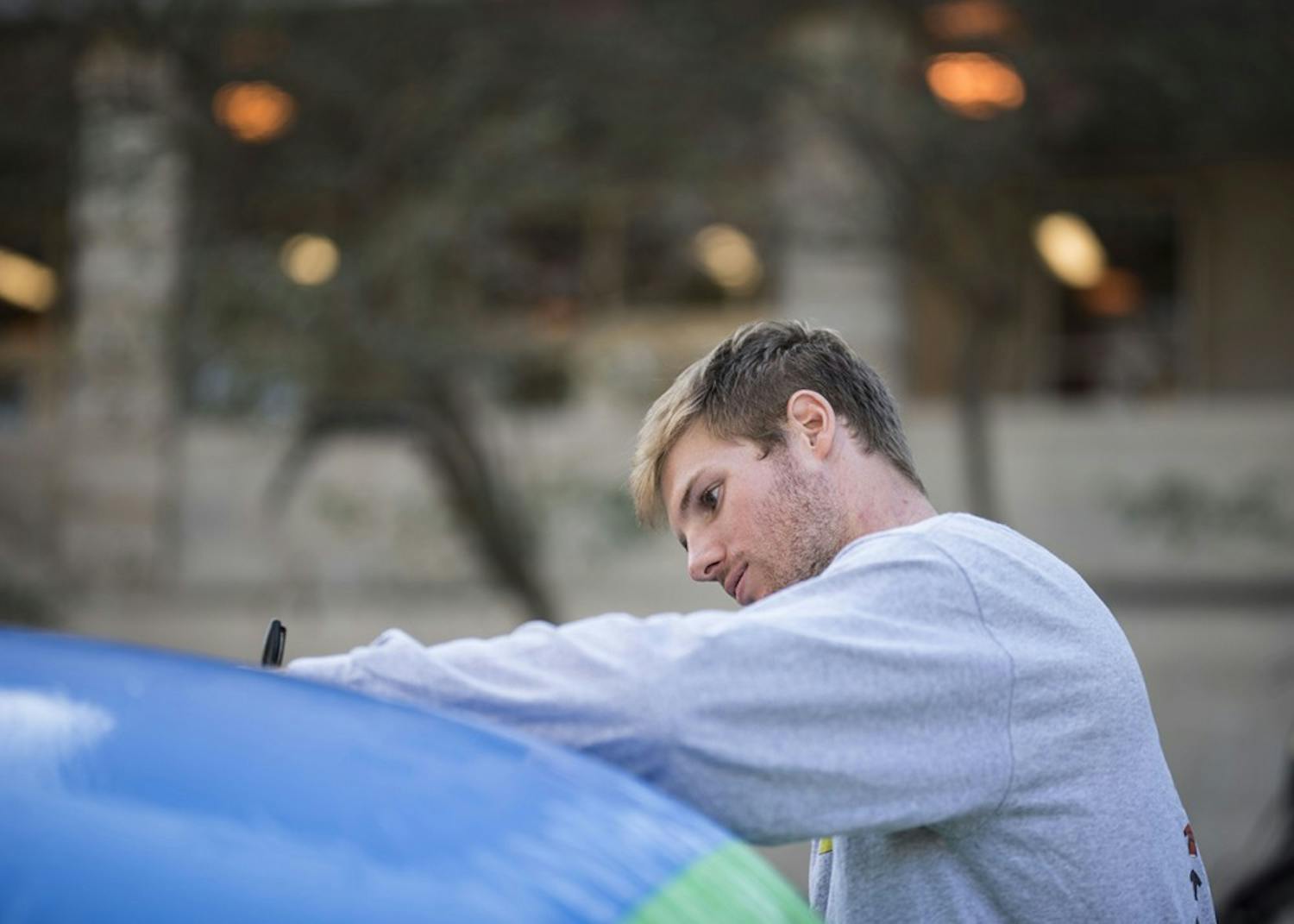 Joe Krahulik, senior, signs the free speech ball outside Ballantine Thursday. Young Americans for Liberty asked people to write whatever they wanted on the giant beach ball in the spirit of free speech.&nbsp;