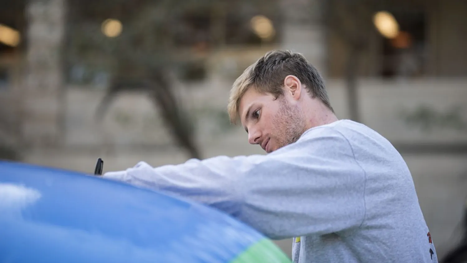 Joe Krahulik, senior, signs the free speech ball outside Ballantine Thursday. Young Americans for Liberty asked people to write whatever they wanted on the giant beach ball in the spirit of free speech. 