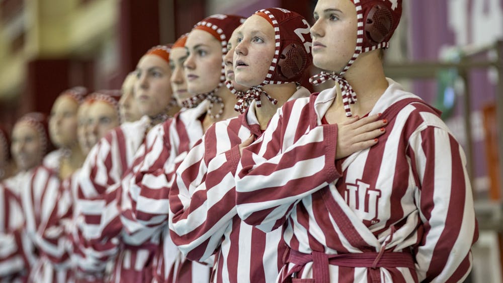 Then-freshman driver Grace Hathaway and the Indiana water polo team stands for the national anthem on March 26, 2022, at the Counsilman Billingsley Aquatic Center. Indiana started its season 2-2 over the weekend.