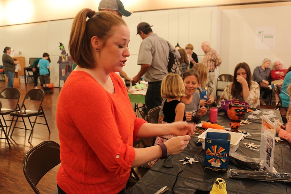 Libba Willcox, volunteer for the fest, helps kids make spooky crafts. 