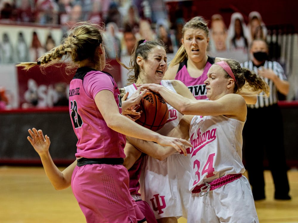 Sophomore forward Mackenzie Holmes and junior guard Grace Berger wrestle for the ball against Iowa on March 3 at Simon Skjodt Assembly Hall. Holmes and Berger were among four IU women&#x27;s basketball players to receive All-Big Ten Honors awards Monday. 