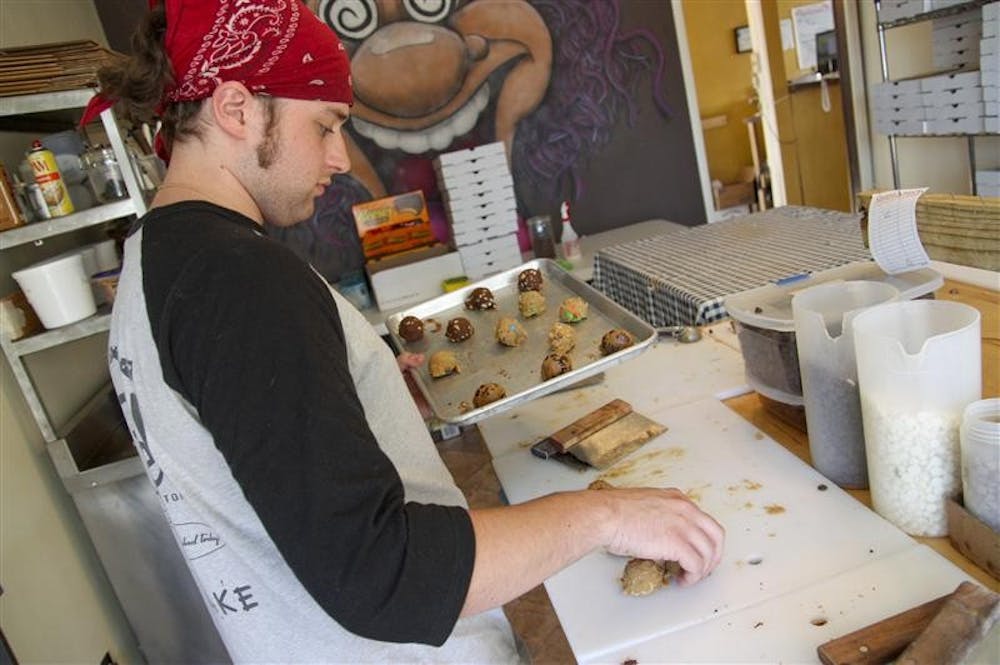 Jared Schneider prepares a custom batch of cookies Saturday afternoon at Baked! of Bloomington.