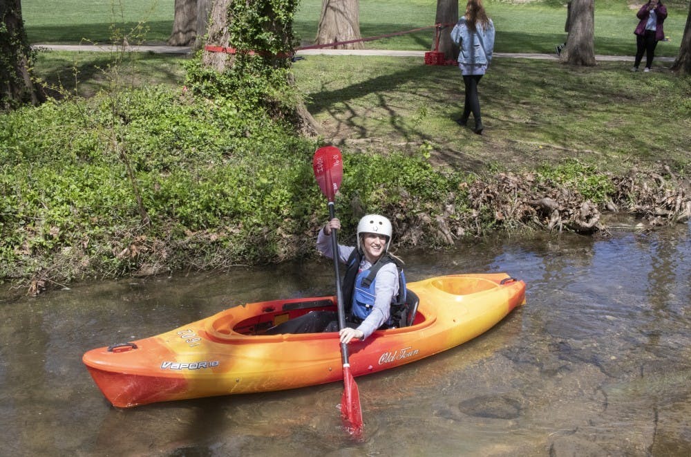 4月15日，二年级学生吉莉安·托梅斯在富兰克林大厅后面的校园河上划皮艇。想在湖上划独木舟、皮划艇或站立式桨板的人可以在格里菲湖租船。